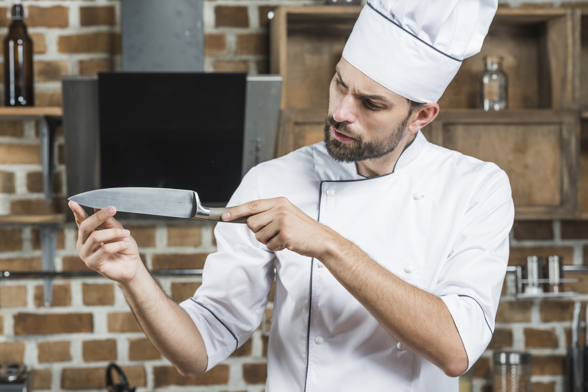 Chef che mostra una tecnica di taglio su tavolo moderno